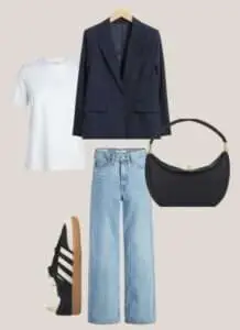 Women's essential clothing pieces, including a classic white shirt, a pair of well-fitting jeans, and a leather jacket, laid out on a table.